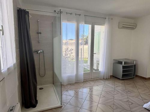 une salle de bain avec une douche avec une porte vitrée dans l'établissement Élégant T2 avec Jardin, Secteur Calme, Proche Mer et Commerces - Latour-Bas-Elne - FR-1-225-650, à Latour-Bas-Elne