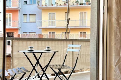 a table and chairs on a balcony with a building at Mary's Home Cogoleto in Cogoleto