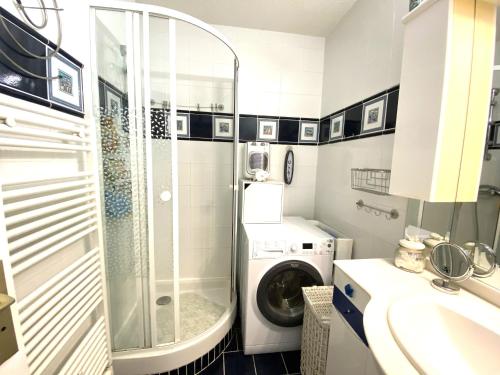 une salle de bain avec une machine à laver et un lave-linge dans l'établissement T2 Moulleau centre parking, clim, wifi,C229, à Arcachon