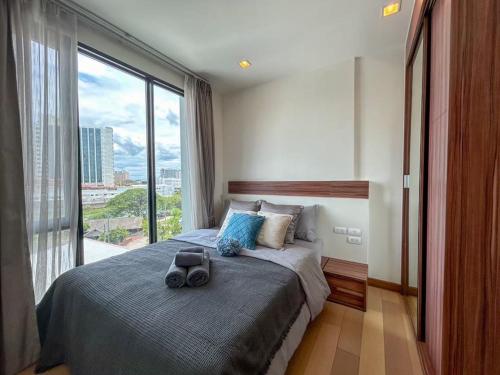 a bedroom with a large bed with a large window at The Astra Luxury Condo near old town in Chiang Mai
