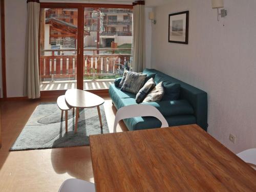 un salon avec un canapé vert et une table dans l'établissement Appartement skis aux pieds avec piscine (6 pers) - Les Orres 1800 - FR-1-322-480, aux Orres