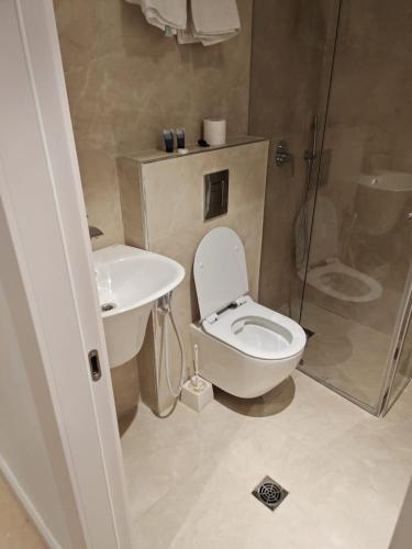 a bathroom with a toilet and a sink and a shower at New Metropole Hotel - Jerusalem in Jerusalem
