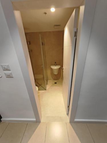 a bathroom with a shower and a toilet and a sink at New Metropole Hotel - Jerusalem in Jerusalem