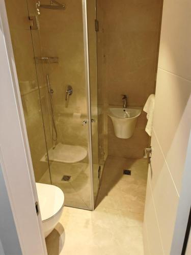 a bathroom with a shower and a toilet and a sink at New Metropole Hotel - Jerusalem in Jerusalem