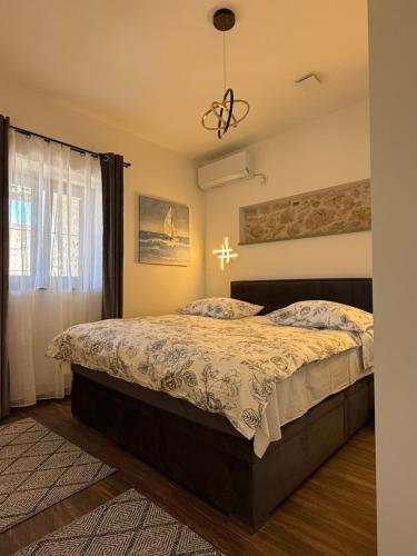 ein Schlafzimmer mit einem Bett und einem Fenster in der Unterkunft Apartment Batinica in Šibenik