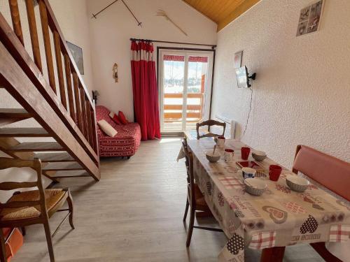 un salon avec une table et un escalier dans l'établissement Studio mezzanine + garage, Les Saisies, 4 pers - FR-1-594-319, à Hauteluce