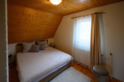 a small bedroom with a bed and a window at Szilvia Vendéghàz in Szarvas