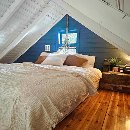 a bed in a room with a blue wall at Lakefront cottage with jacuzzi in Borgarnes