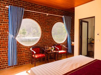 a bedroom with two windows and a brick wall at Tam Coc Moutainside Homestay in Ninh Binh