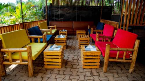 a row of colorful chairs and tables on a patio at Noaz Hotel in Kampala