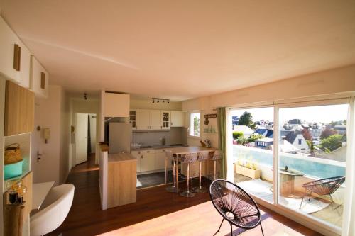 a kitchen and living room with a view of a pool at Appartement et terrasse Port du Pouliguen in Le Pouliguen