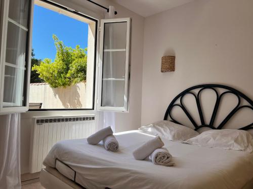 une chambre avec un lit et une grande fenêtre dans l'établissement Jolie maison lumineuse, à La Flotte