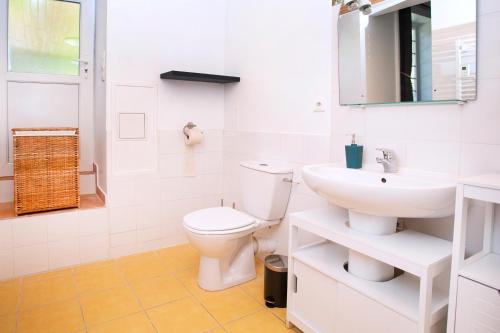 a white bathroom with a toilet and a sink at La Mancellière de Montjoie chambres d'hôtes et gîtes in Saint-Michel-de-Montjoie