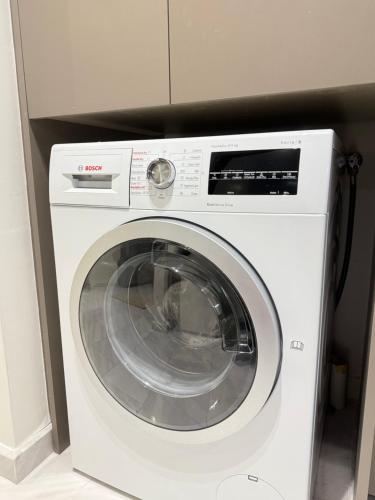 a white washing machine sitting in a kitchen at Eaton Residences KLCC By ARBAN in Kuala Lumpur