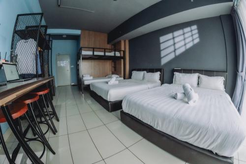a hotel room with two beds and a bar at Aeropod Cactus Rail Suite With Balcony - Kota Kinabalu in Kota Kinabalu
