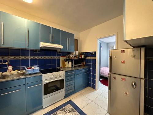 una cucina con mobili blu e un frigorifero in acciaio inossidabile di Apartman Nenezic a Budua