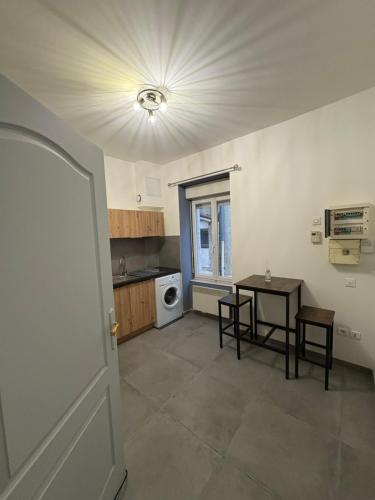 un salon avec une table et une cuisine dans l'établissement Studio cosy, à Le Teil