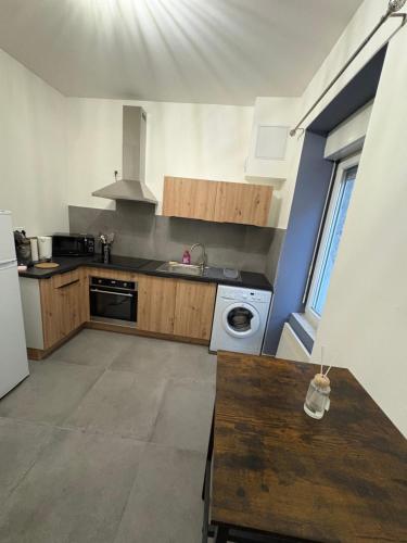 une cuisine avec un évier et une cuisinière dans l'établissement Studio cosy, à Le Teil