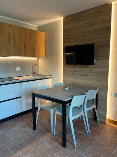 a kitchen with a black table and two white chairs at Chalet La Stella Alpina in Ponte di Legno