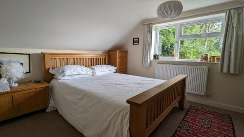 una camera da letto con un letto grande e una finestra di Rose Cottage a Ledbury