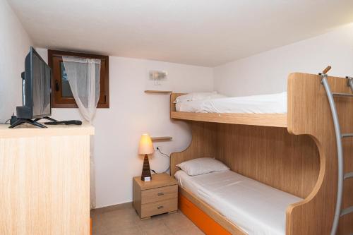 a room with two bunk beds and a television at Casa Vacanze - L'Ancora in Stintino