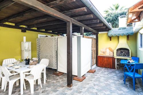 a patio with a table and chairs and a fireplace at Casa Vacanze - L'Ancora in Stintino