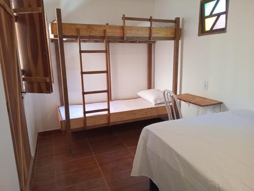 a room with two bunk beds in a room at Quarto para 4 a 900 metros da Vila do Capão ll in Vale do Capao
