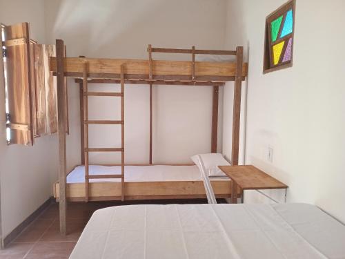 a bedroom with a bunk bed and a desk at Quarto para 4 a 900 metros da Vila do Capão ll in Vale do Capao