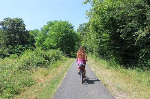 a girl riding a bike down a road at Atena Bordeaux Sud Est Créon - Vélo Friendly in Créon