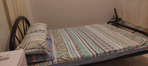 a bed with a quilt on top of it at GGGO RESIDENCES, Studio 103, King in Sorsogon