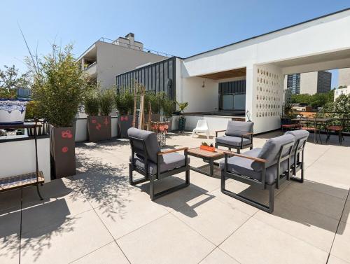 un patio avec des chaises et une table dans un bâtiment dans l'établissement Le Penthouse de Boulogne, à Boulogne-Billancourt