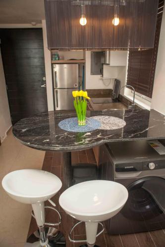 a kitchen with a counter with a vase with yellow flowers on it at Midtown Apto in Town Center in Río Hato