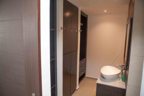 a small bathroom with a toilet and a cabinet at Midtown Apto in Town Center in Río Hato