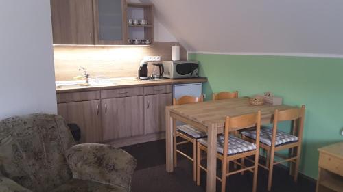 a kitchen with a table and chairs and a sink at APARTMÁNY - Pacholik in Rokytnice nad Jizerou