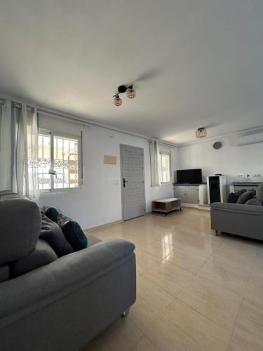 Una sala de estar con un sofá y un televisor. en Villa Moore, en Mazarrón