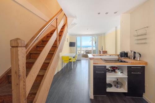 une cuisine avec un escalier menant à un loft dans l'établissement Appartement Vue Exceptionnelle 2Ch - Sur La Plage, au Grau-du-Roi