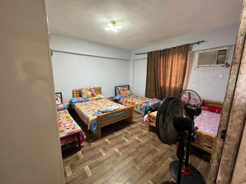 a room with three beds and a camera at شاليه راكان الاستجمام صف أول على البحر in Ras Sedr
