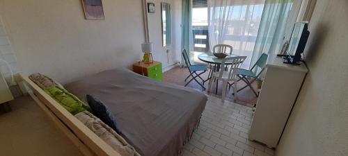 - une chambre avec un lit, une table et un balcon dans l'établissement Studio 613, Port Nature 6 au village naturiste, au Cap d'Agde