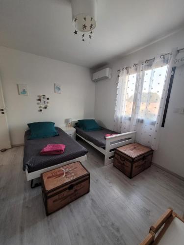 - une chambre avec 2 lits et 2 malles dans l'établissement Maison de vacances avec piscine près de Montpellier, à Saint-Drézéry