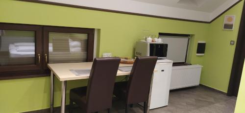 a kitchen with a table with chairs and a microwave at Erika Vendégház in Mogyoród