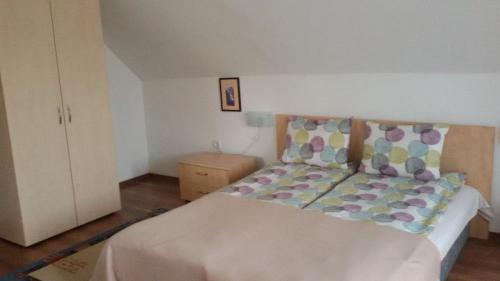 a bedroom with a large white bed with colorful pillows at Casa Dancs in Covasna