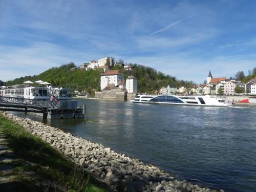 a river with a boat docked at a dock at Dreiländereck mit Sauna und Pool, Wohnung 403 in Hauzenberg