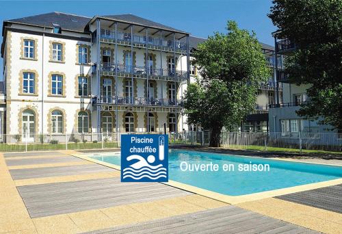 un bâtiment avec un panneau en face d'une piscine dans l'établissement St-Goustan à bâbord - Les Gîtes de la Côte d'Amour, au Croisic