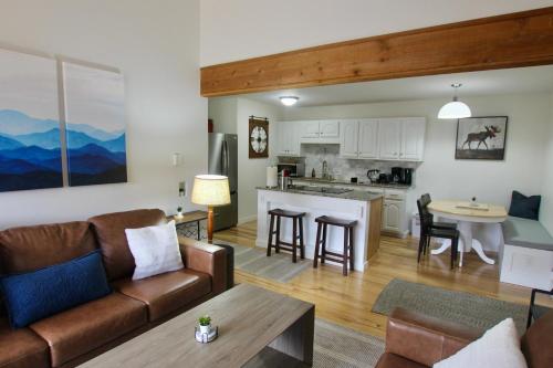 a living room and kitchen with a couch and a table at Beaver Creek, Avon condo, walk to ski shuttle - on the Eagle River in Avon