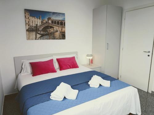 a bedroom with a blue and white bed with red pillows at Venice Luxury Apartment in Venice
