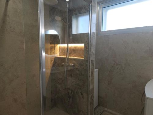 une douche avec une porte vitrée dans une salle de bain dans l'établissement Centre Antibes Le Piadon 3 pièces neuf Parking, à Antibes