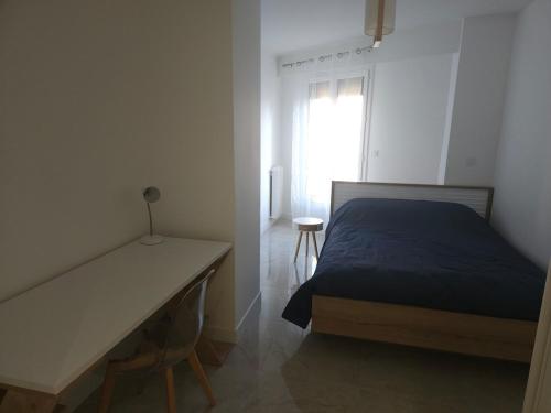une chambre avec un lit, un bureau et une fenêtre dans l'établissement Centre Antibes Le Piadon 3 pièces neuf Parking, à Antibes