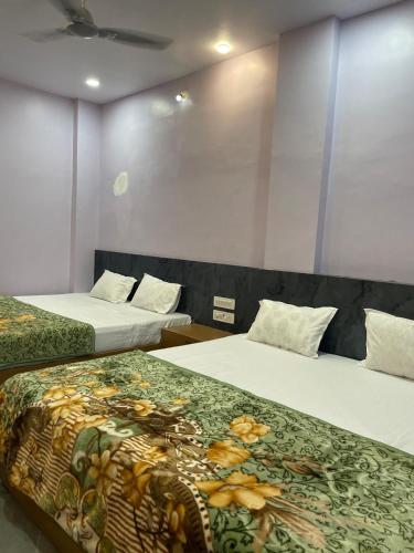 two beds in a hotel room with two beds sidx sidx sidx at Hotel swastik Inn in Ujjain