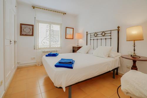 a bedroom with a large white bed with blue towels on it at Rentalsbcn Volantí in Blanes