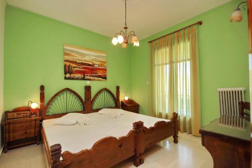 a bedroom with a large bed with green walls at Hotel Marialena in Ancient Epidavros